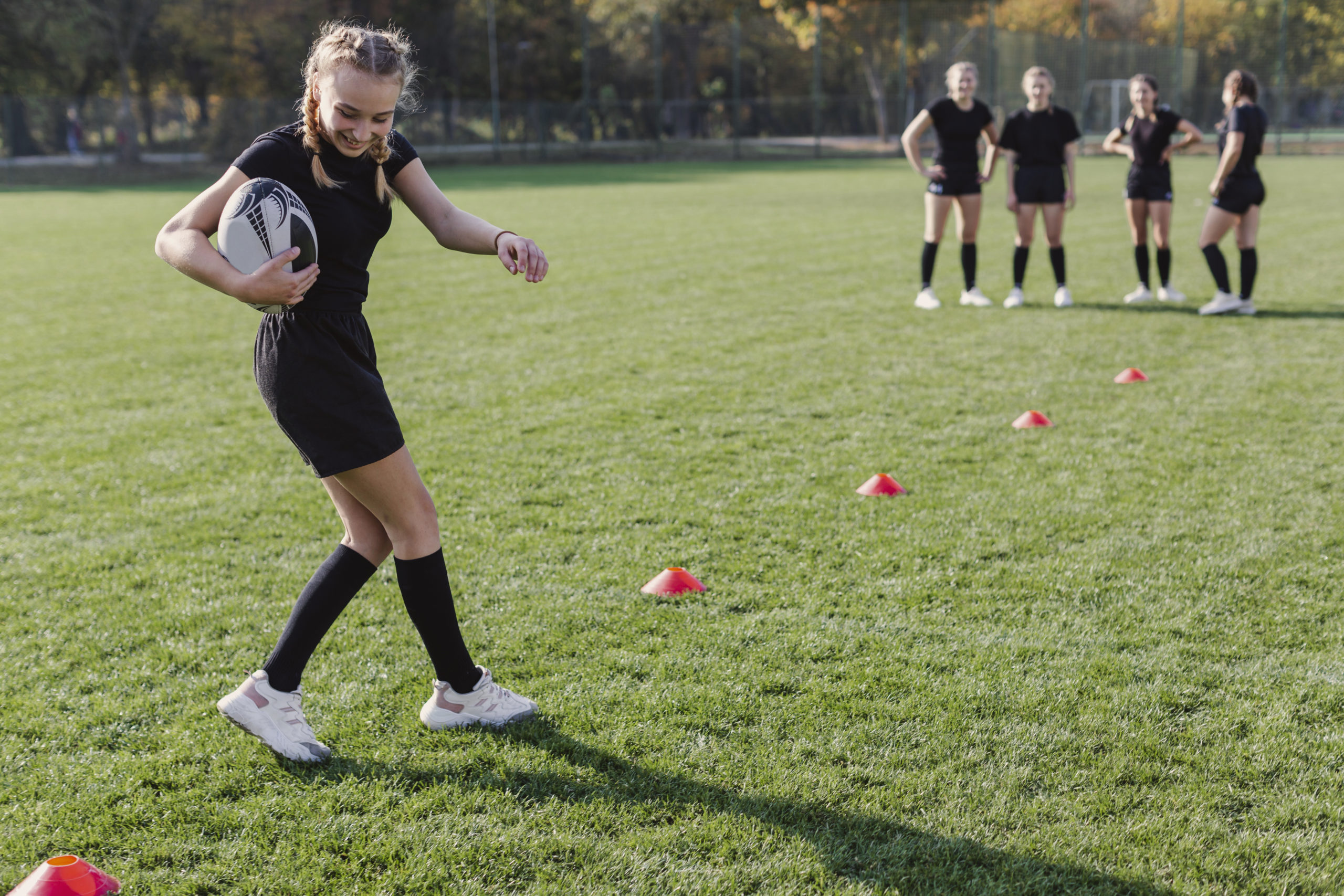 smiling-blonde-girl-running-through-cones